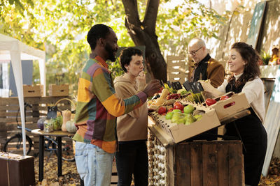 Female friends working at market stall