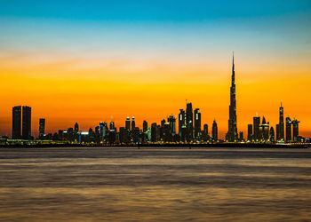 View of illuminated buildings against sky during sunset