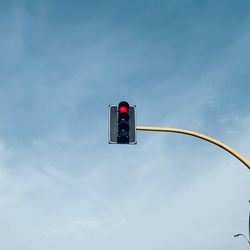 Low angle view of road signal against sky