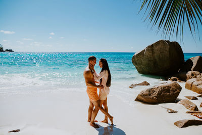 Side view of smiling couple romancing at beach