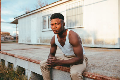 Full length of young man sitting outdoors