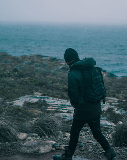 Side view of person hiking on mountain against sea