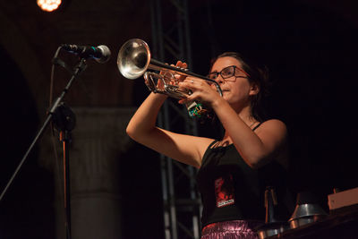 Midsection of young woman holding hands at music concert