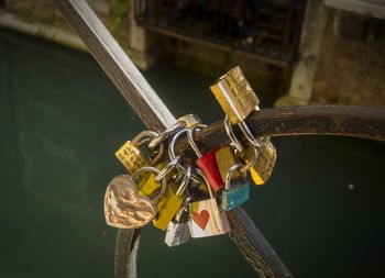 Close-up of padlocks on railing against canal