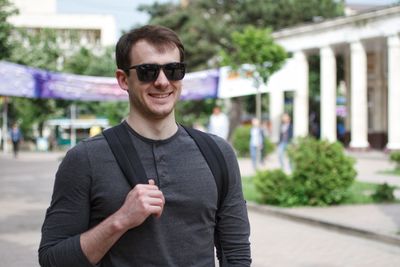 Portrait of young man wearing sunglasses standing in city