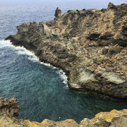 High angle view of rocks on sea shore