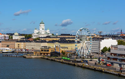 Helsinki cityscape shot from water with white helsinki cathedral, big ferry wheel and city roofs