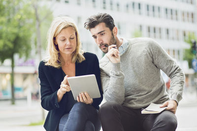 Business people using digital tablet outdoors