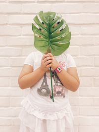 Midsection of girl holding leaf