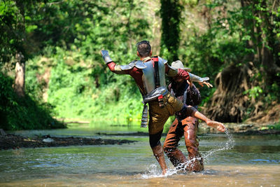 People practicing on river in forest