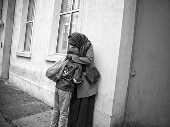 Rear view of man standing against wall