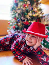 Portrait of cute boy wearing hat christmas tree