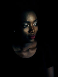 Close-up of young woman looking away in darkroom