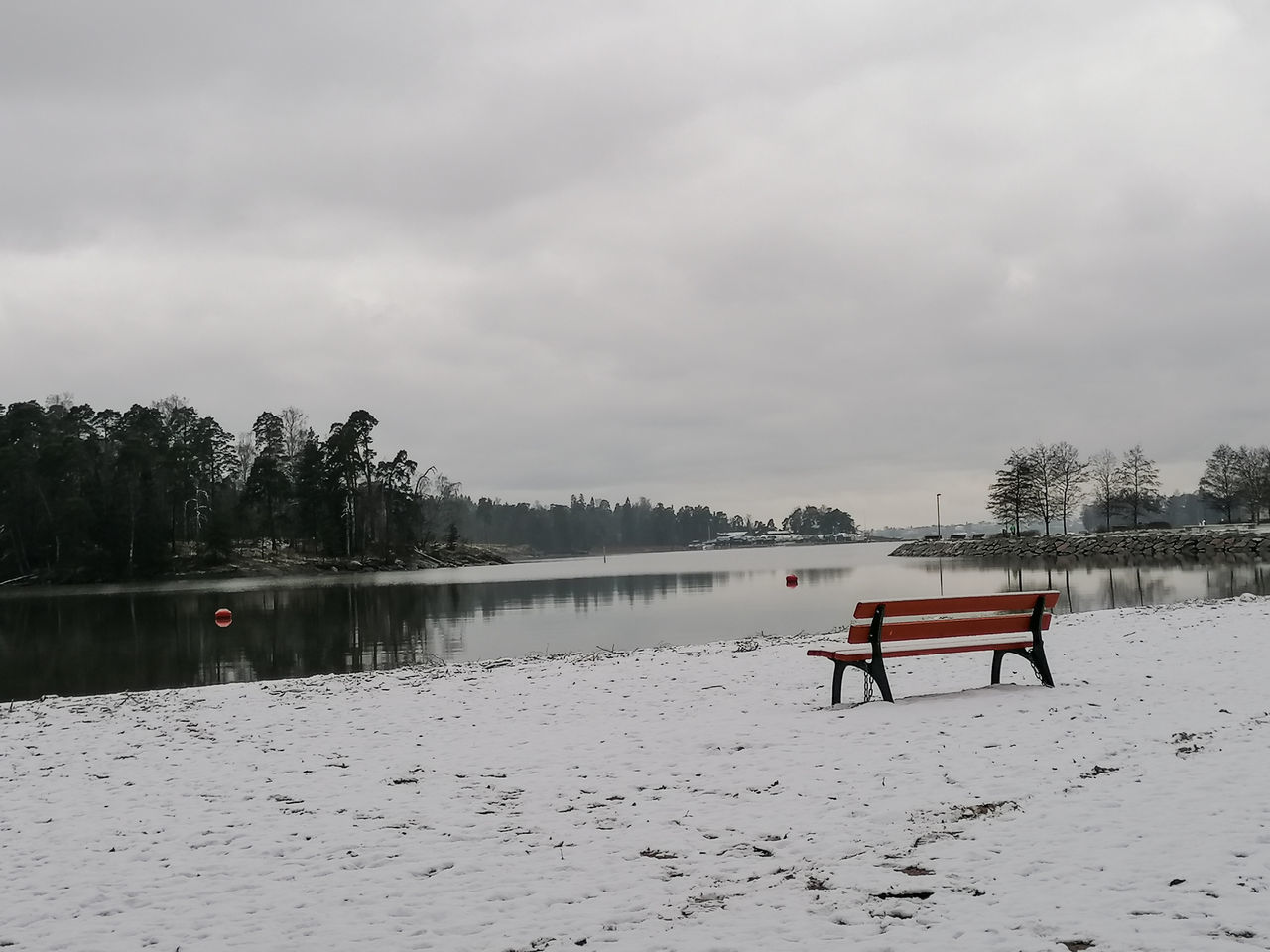 PARK BENCH BY LAKE AGAINST SKY