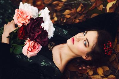 Close-up portrait of young woman with roses