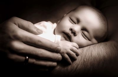 Close-up of cute baby sleeping on hand