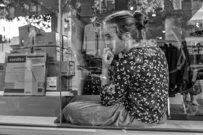 Side view of a young woman sitting on floor