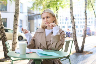 Young woman using mobile phone in cafe