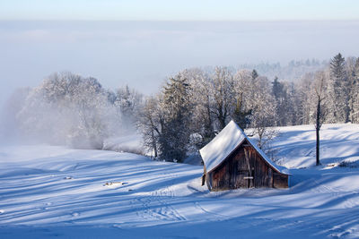 Built structure on snow field against sky