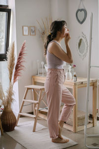 Woman standing on table at home