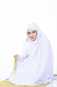 Portrait of a smiling young woman against white background