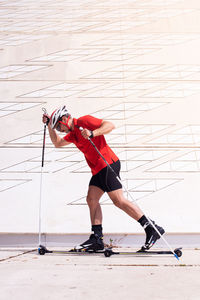 Side view of man with ski roller against wall