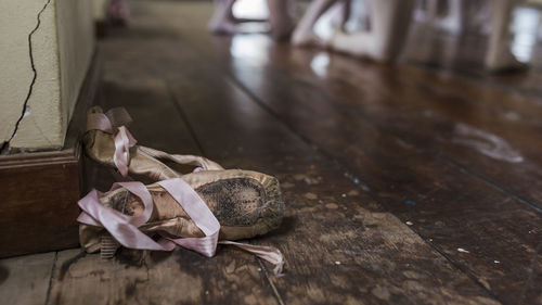 Close-up of ballet shoe on hardwood floor