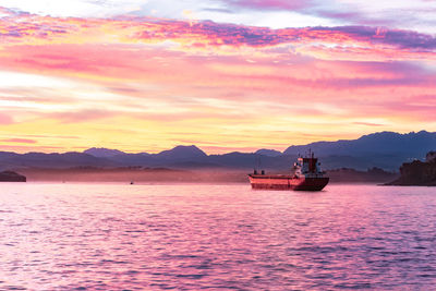 Boat sailing on sea against sky during sunset