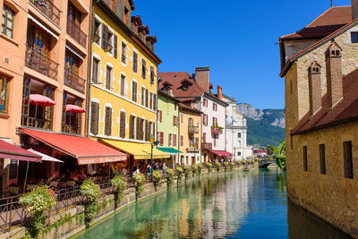 Canal amidst buildings in town against sky