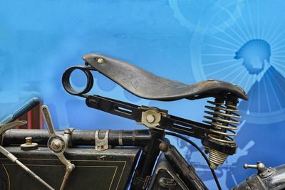 Close-up of old bicycle wheel against blue sky