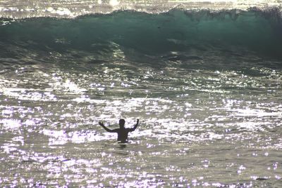 Silhouette man swimming in sea