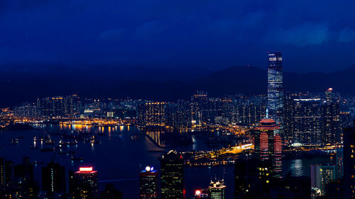 High angle view of illuminated city buildings against sky at night