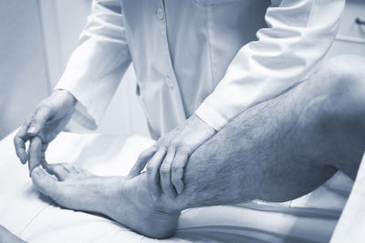 Close-up of doctor examining patient foot in hospital