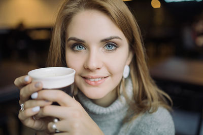 Portrait of a young woman drinking coffee