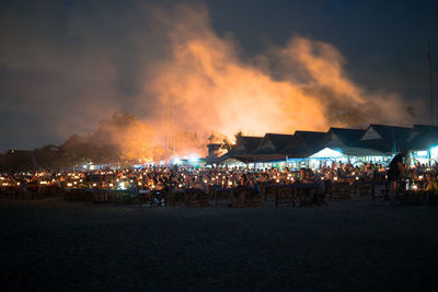 People at beach against sky at night
