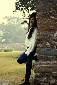 Portrait of woman standing against tree