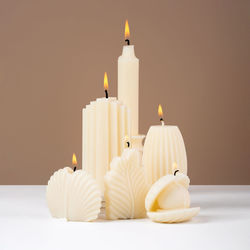 Close-up of illuminated candles on white background