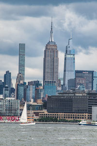 Modern buildings in city against cloudy sky