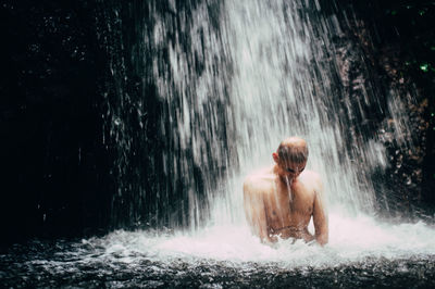 Man under waterfall