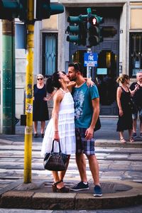 Full length of people walking on footpath in city