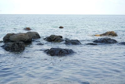 View of rocks in sea against sky