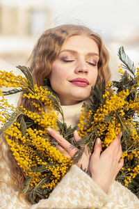 A woman  with a bouquet of yellow acacia flowers.the concept of the- march 8, easter, women's day.