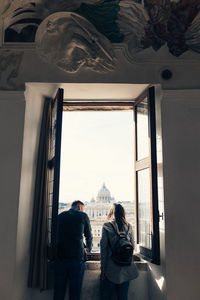 Rear view of people sitting at window