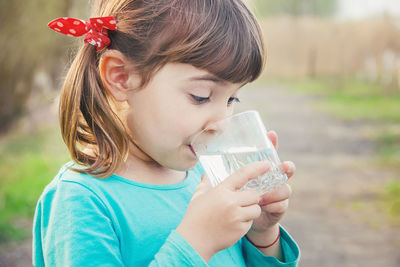 Close-up of girl blowing flowers