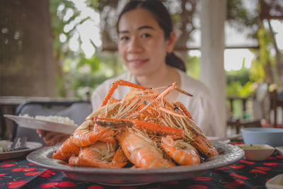 The steamed shrimp on the plate with woman