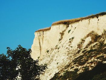 Low angle view of rock formation against clear blue sky