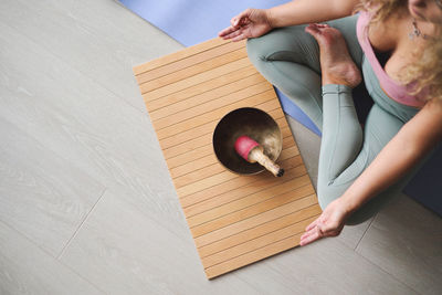 Low section of woman doing yoga at home