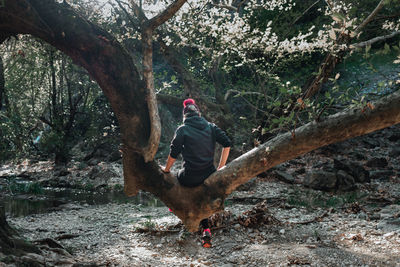 Rear view of woman  amidst trees in forest