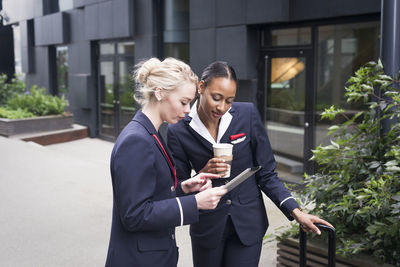 Two female flight attendants looking at digital tablet