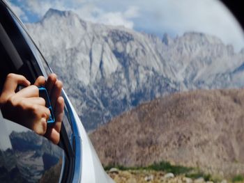 Close-up of hand holding car in mountains